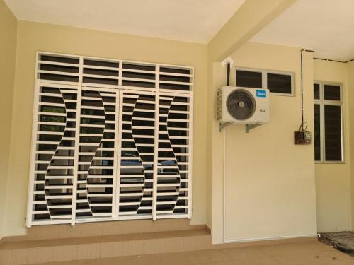 een kamer met een raam met jaloezieën en een radio bij Eiman Homestay in Kuala Terengganu