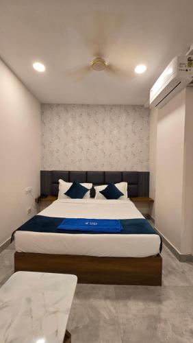 a bedroom with a large bed with blue pillows at Elite Hotel Karimnagar in Kottapalli