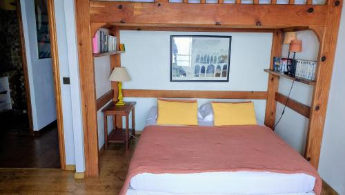 a bedroom with a wooden bed with yellow pillows at Villa St Michel in Brando