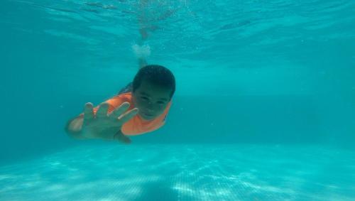 ein kleines Kind schwimmt im Wasser in der Unterkunft El Cottage de Vaco in Canoas
