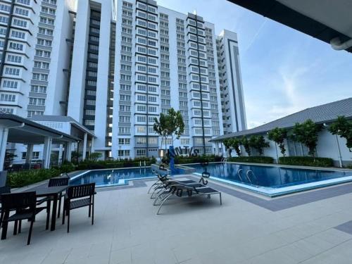 a patio with tables and chairs next to a swimming pool at The Duta Loft in Bandar Puncak Alam