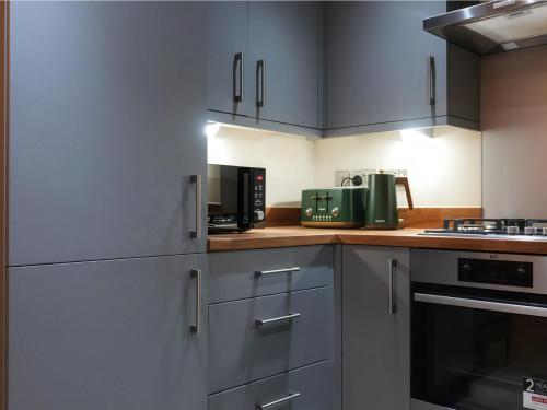 a kitchen with stainless steel cabinets and a microwave at Adeluxe Aura - Entire Ultra Luxury- Super King Bed with Free WiFi, Netflix and Amazon Prime in Burton upon Trent