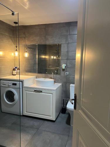 a bathroom with a sink and a washing machine at Kutaisi Glow in Kutaisi