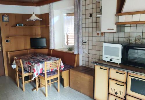 a small kitchen with a table and a microwave at Casa Checolongo in Ziano di Fiemme