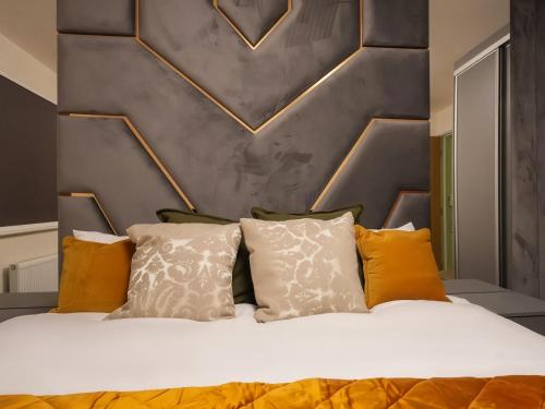 a bedroom with a bed with yellow and white pillows at Adeluxe Aura - Entire Ultra Luxury- Super King Bed with Free WiFi, Netflix and Amazon Prime in Burton upon Trent