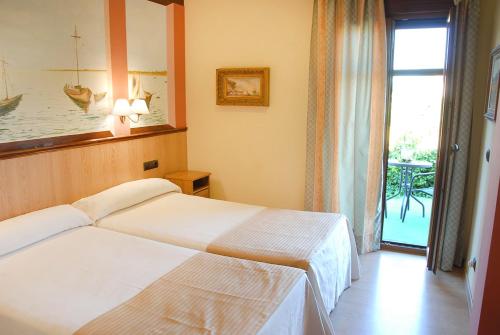 Hotel Pinomar في إل بويرتو دي سانتا ماريا: غرفة فندقية بسريرين ونافذة