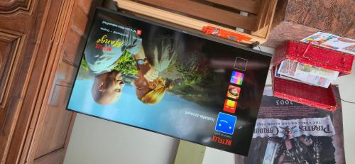 a flat screen tv hanging on a wall at Chambre d'hôte - La Maison Verte in Charmes