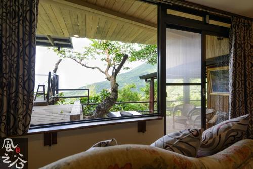 een kamer met een groot raam met uitzicht op een boom bij Jiufen Fongigu Homestay in Jiufen