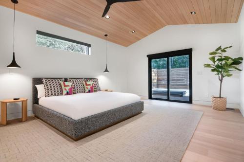 Un dormitorio con una cama y una planta en maceta. en RMR: Tensleep Oasis Home in The AspensWilsonWY, en Wilson