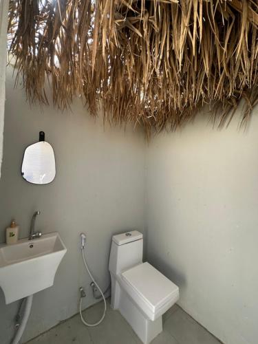 Un baño con un inodoro blanco y un lavabo. en Royal desert camp, en Al Raka