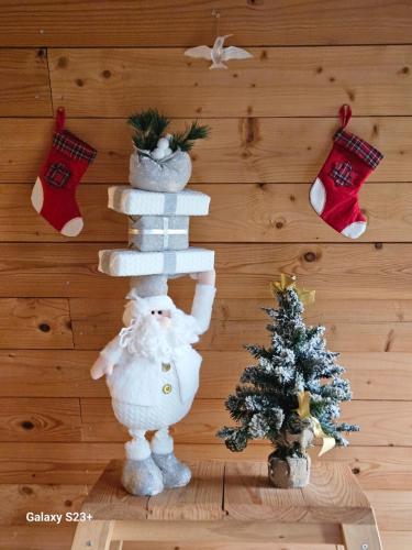 a santa claus figurine next to a christmas tree at LOGIS LAS CROZAS Le Mousseron orientable in Vernines