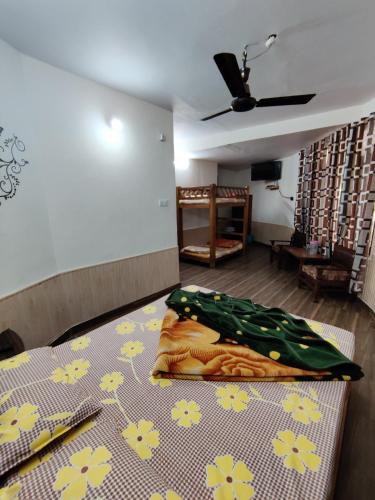 a bedroom with a bed with flowers on it at Hotel Alankar in Manāli