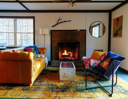 ein Wohnzimmer mit Couch und Kamin in der Unterkunft Rustic Mountain Cabin with Porch & Fire Pit in New Market, Virginia in New Market