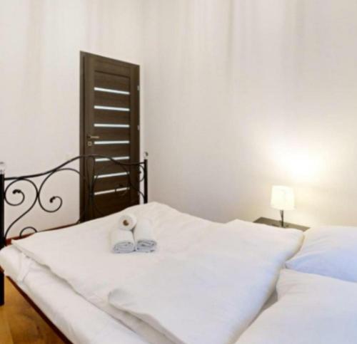 a white bed with a pair of slippers on it at Rynek aparts in Wrocław