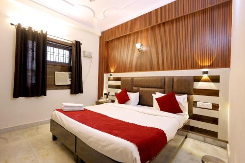a bedroom with a large bed with red pillows at Hotel Basil Inn in Agra