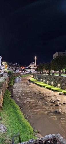 Ein Fluss bei Nacht mit einem Kreuz im Hintergrund in der Unterkunft Locker in Prizren