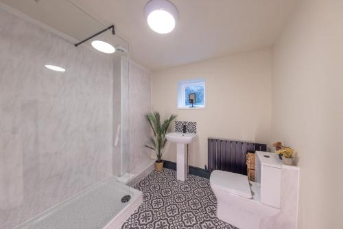 a bathroom with a tub and a toilet and a sink at Cottage style with lovely mountain views in Moffat
