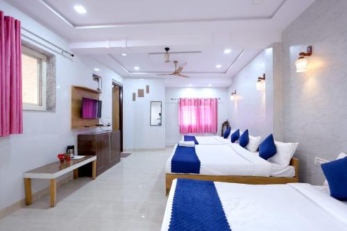 a hotel room with two beds and a desk at Hotel Basil Inn in Agra