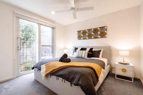 a bedroom with a bed and a large window at Rooftop deck - Central OG - Seaview Luxe in Ocean Grove