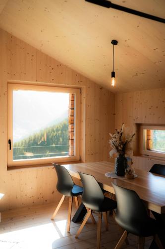 a dining room with a table and chairs and a window at Le Mayen ALTYPIC in Bruson