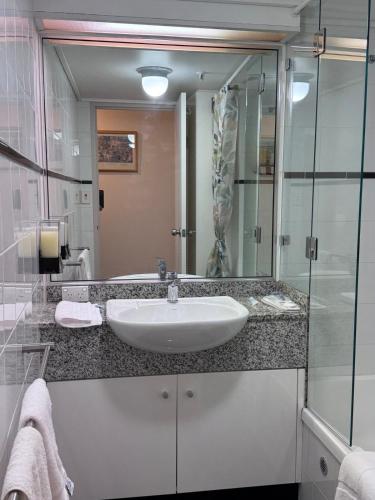 a bathroom with a sink and a large mirror at Garden Gallery - Tranquil Luxury Retreat in Canberra