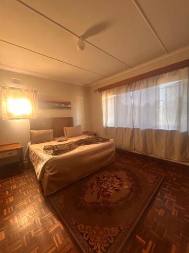 a bedroom with a bed and a window and a rug at Nathi Lodge in New Germany