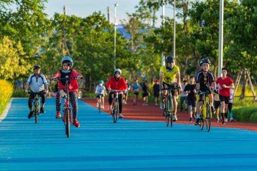 a group of children riding bikes down a road at GO INN Suvarnabhumi Airport Bangkok in Lat Krabang