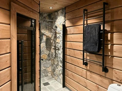 a bathroom with a wooden wall and a door at Mountain Lodge With Views Over Idre in Idre