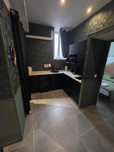 une petite cuisine avec un évier et une fenêtre dans l'établissement Love room - Jacuzzi - Salle de jeux complète, à Reims