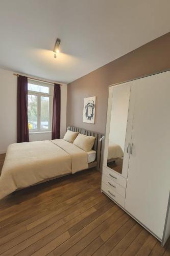 ein Schlafzimmer mit einem Bett und einem weißen Schrank in der Unterkunft Le cocon in Verdun-sur-Meuse