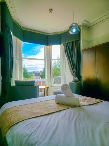 a bedroom with a large bed with a window at Lovat Hotel in Perth