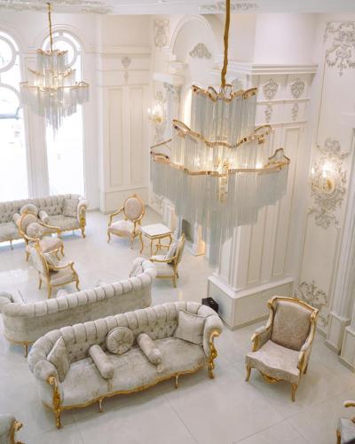 a living room with couches and chairs and a chandelier at White Domes Hotel in Baghdād