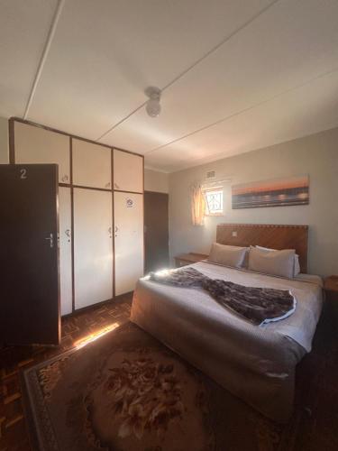 a bedroom with a large bed and a rug at Nathi Lodge in New Germany