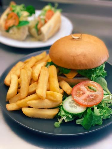 a blue plate with a sandwich and french fries at Dare Valley Accommodation and Campsite in Aberdare