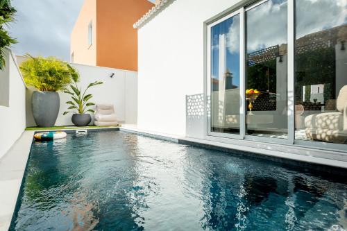 a swimming pool in the middle of a house at New Villa Los Olivos in Adeje