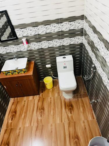 a bathroom with a toilet and a sink at Himalayan Hill Top Resort in Kanatal