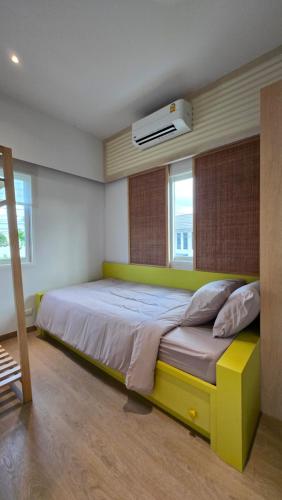 a bedroom with a large bed with a yellow frame at 18TU Thammasat in Pathum Thani