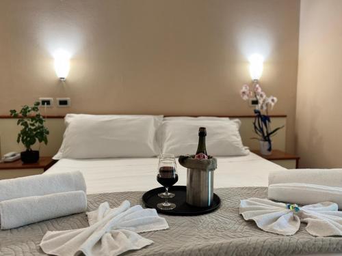 a bedroom with a bed with a bottle of wine and towels at Depandance Blue Hotel in Cesenatico