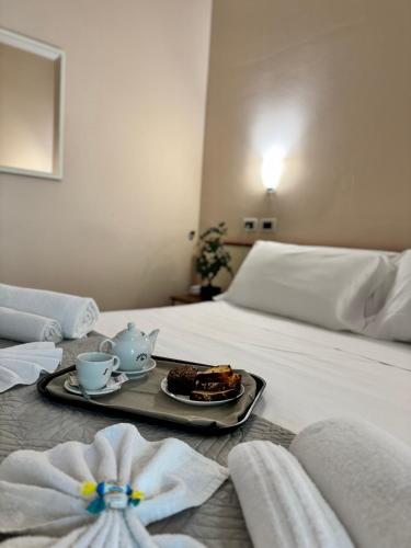 a hotel room with a tray of food on a bed at Depandance Blue Hotel in Cesenatico