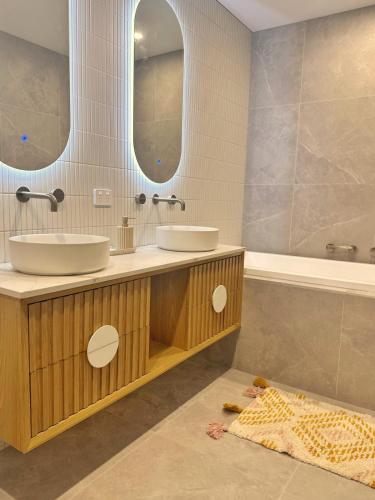 ポートアーリントンにあるCoastal on Clarkeの洗面台が2つと大きな鏡があるバスルーム