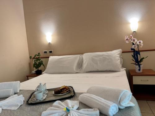 a hotel room with a bed with a tray of food on it at Depandance Blue Hotel in Cesenatico