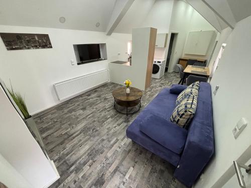 a living room with a blue couch and a table at Ferienwohnung zur Fröhlichkeit II in Niederdorla