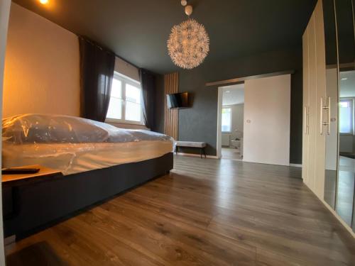 a bedroom with a large bed and a chandelier at Atelier 1a in Cottbus