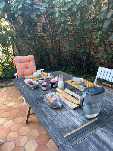 a wooden picnic table with food on it at Maison Garesché - idéal télétravail & nature in Nieulle-sur-Seudre