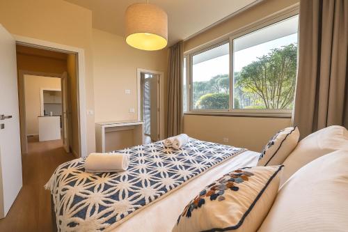 een slaapkamer met twee bedden en een groot raam bij Green garden apartment in Lignano Sabbiadoro