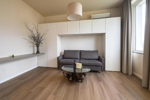 een woonkamer met een bank en een tafel bij Green garden apartment in Lignano Sabbiadoro