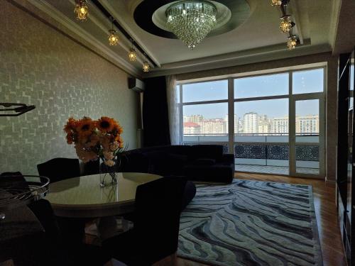 ein Wohnzimmer mit einem Tisch und einem großen Fenster in der Unterkunft central apartment in Baku