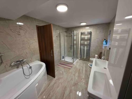 um banheiro com banheira, vaso sanitário e pia em Apartmán v pekárně em Vejprty