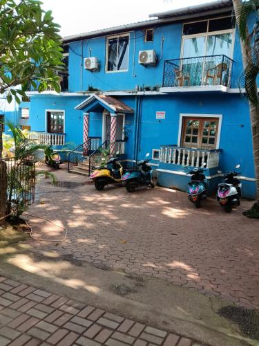 a blue building with scooters parked in front of it at Casa Sumanjo in Calangute