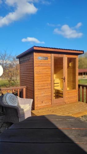a wooden shed with a bench on a deck at Family Mountain Cottage in Cârțișoara